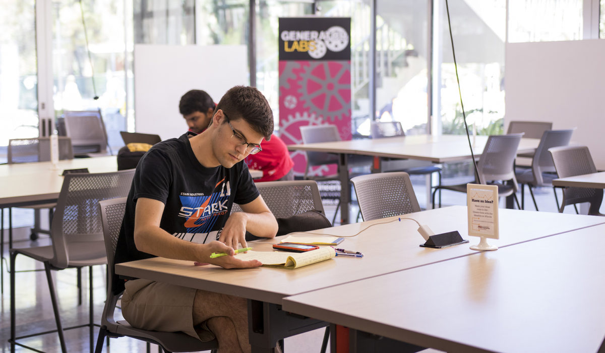 Photo of a student working at a table in the Generator Labs. Caption: Getting a head start on classes at Generator Labs. Photographer: Marco-Alexis Chaira/ASU