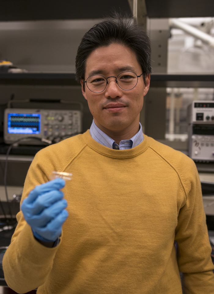 Portrait of Junseok Chae holding a device. Caption: Junseok Chae holds a prototype of the wireless, fully passive multi-channel neural recorder his team is developing. Photographer: Marco-Alexis Chaira/ASU