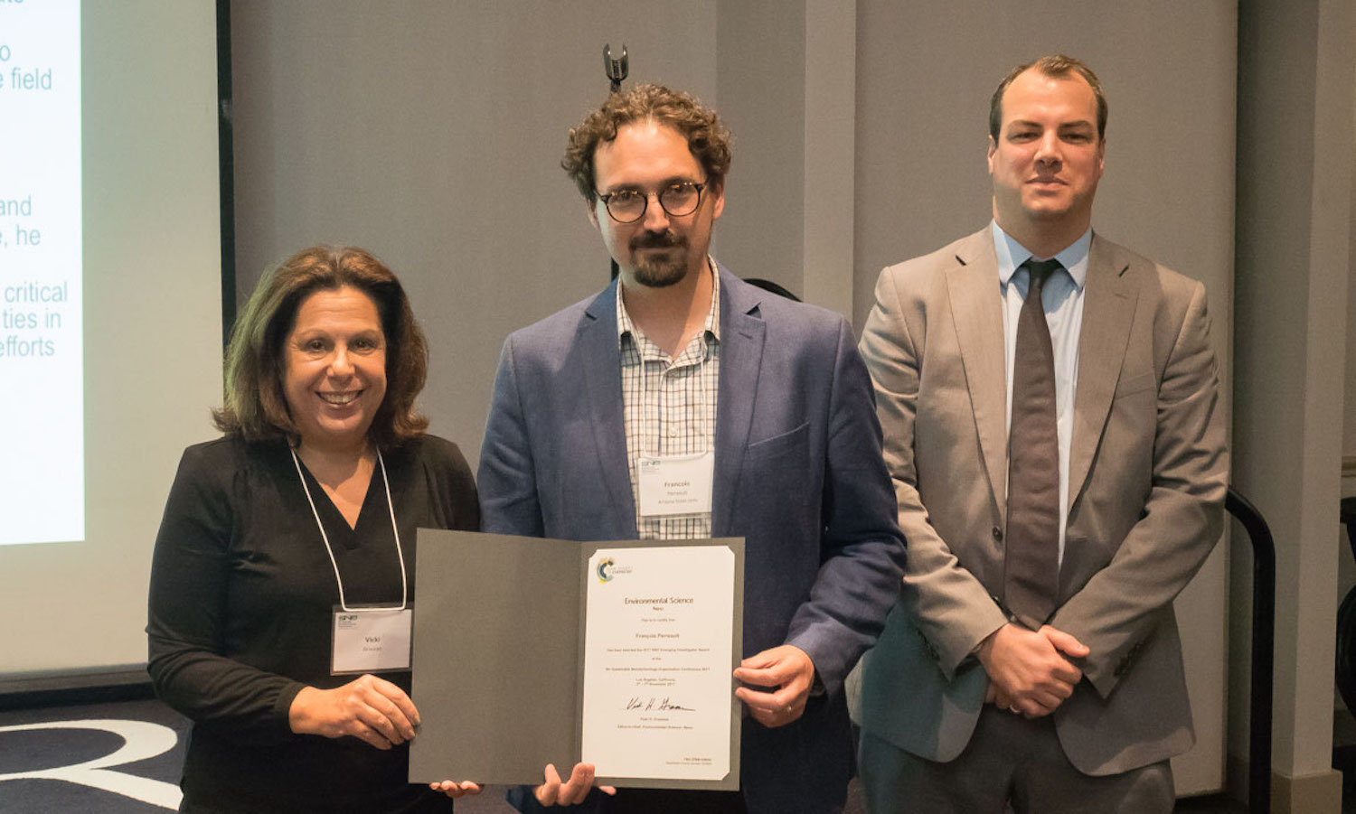 Photo of three people standing in a row with the middle one holding a certificate. Caption: Assistant Professor Francois Perreault’s research has had a significant impact on the use of nanomaterials in a variety of biological, chemical and environmental processes, including those related to water treatment. Photographer: Ana Barrios/ASU