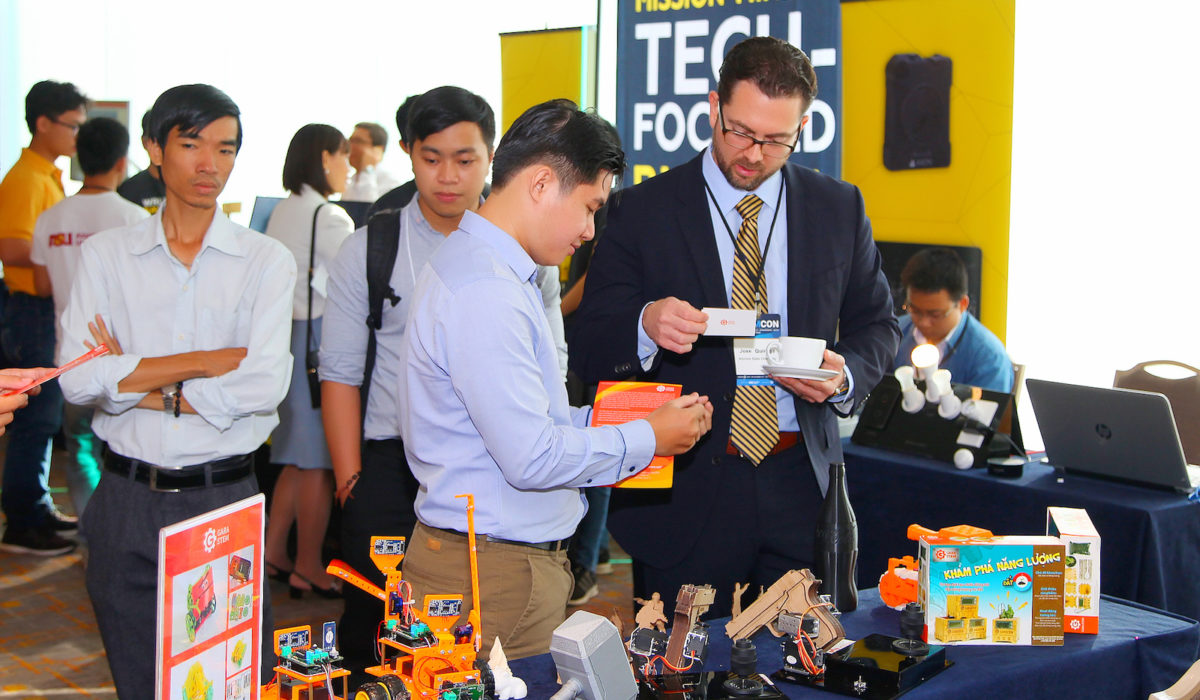 Jose Quiroga (foreground, far right), associate director of the Office of Global Outreach and Extended Education, visits the GaraSTEM booth in the STEMCON Showcase Exhibition during a conference break.