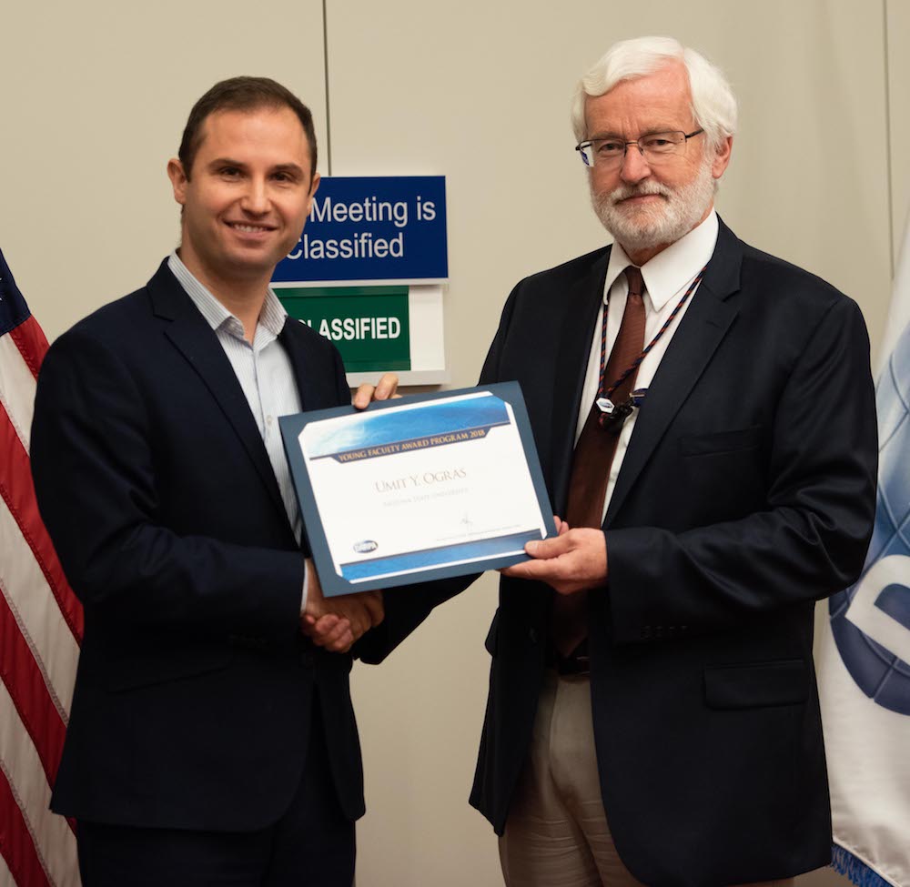 two men standing holding a certificate
