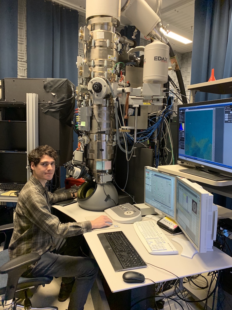 man sitting at a microscope