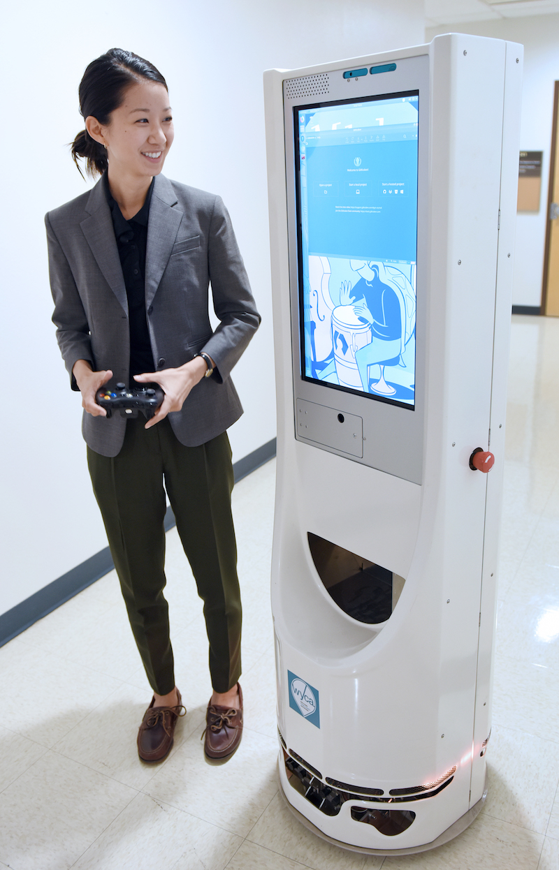 Erin Chiou standing next to a mobile robot
