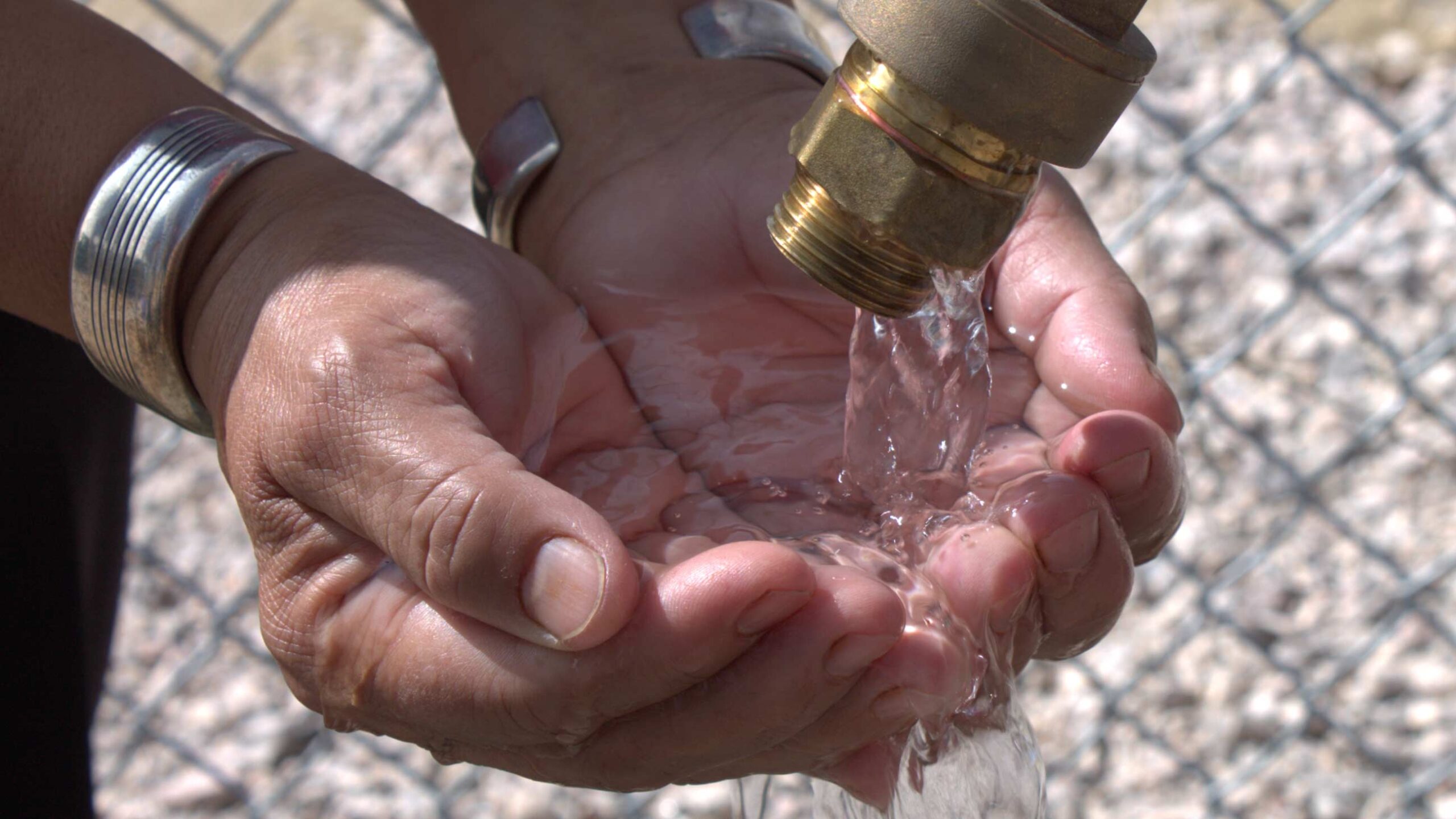 a pair of hands under flowing water